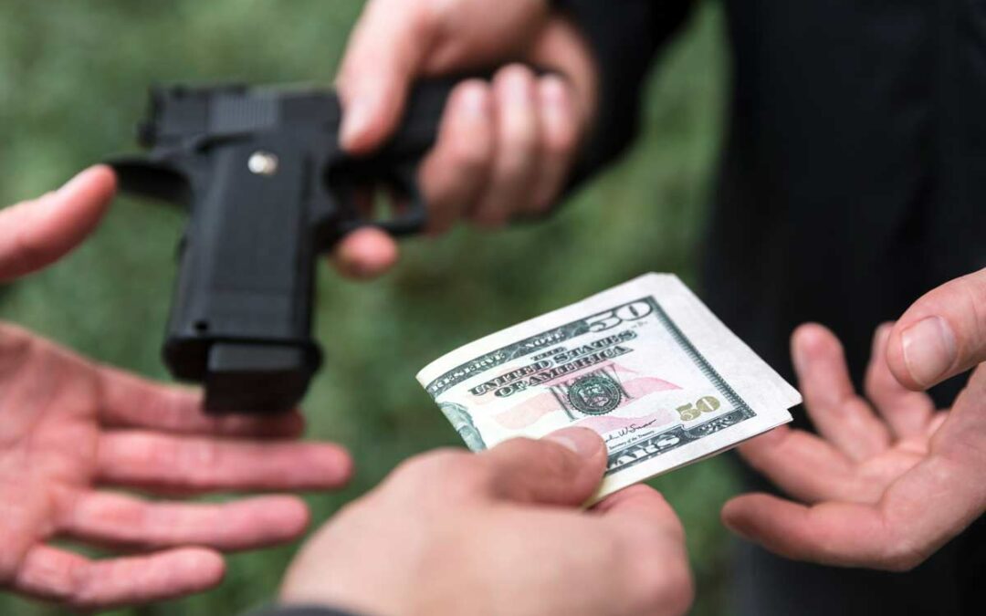 hands exchanging money for a gun